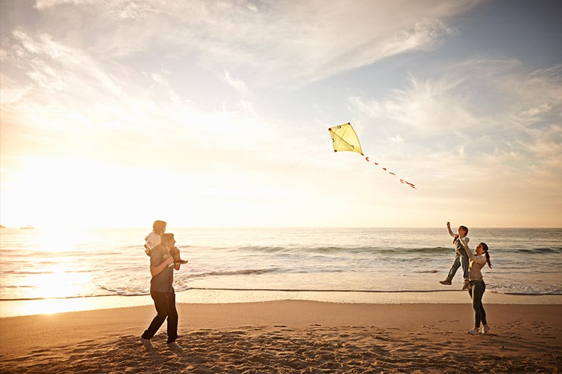 Family on the beach flying a kite