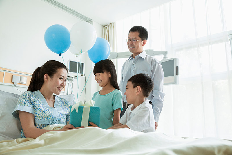 gift-banner.jpg Family giving mom a gift in the hospital