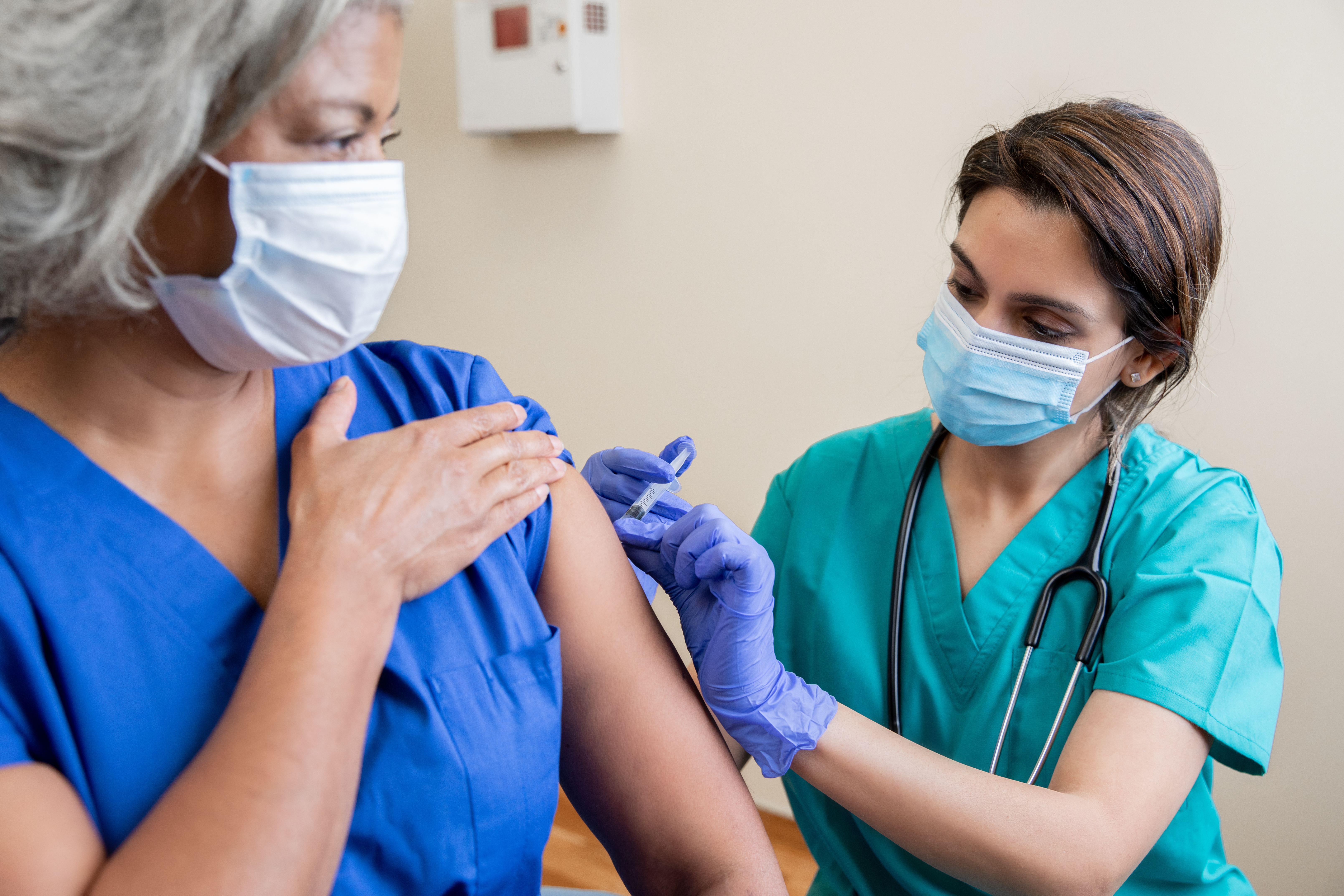 nurse giving a woman a flu shot