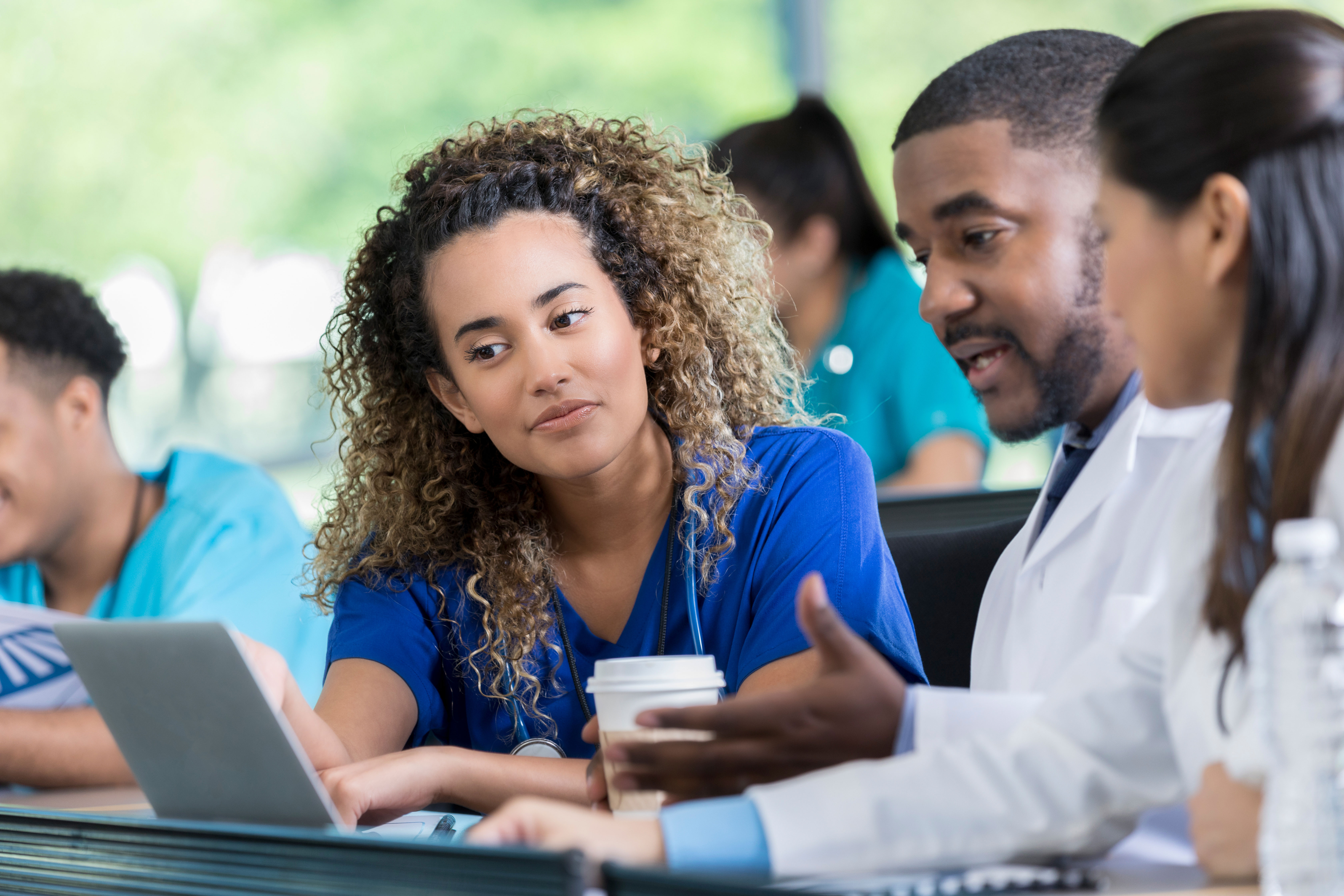 Healthcare students look at a laptop