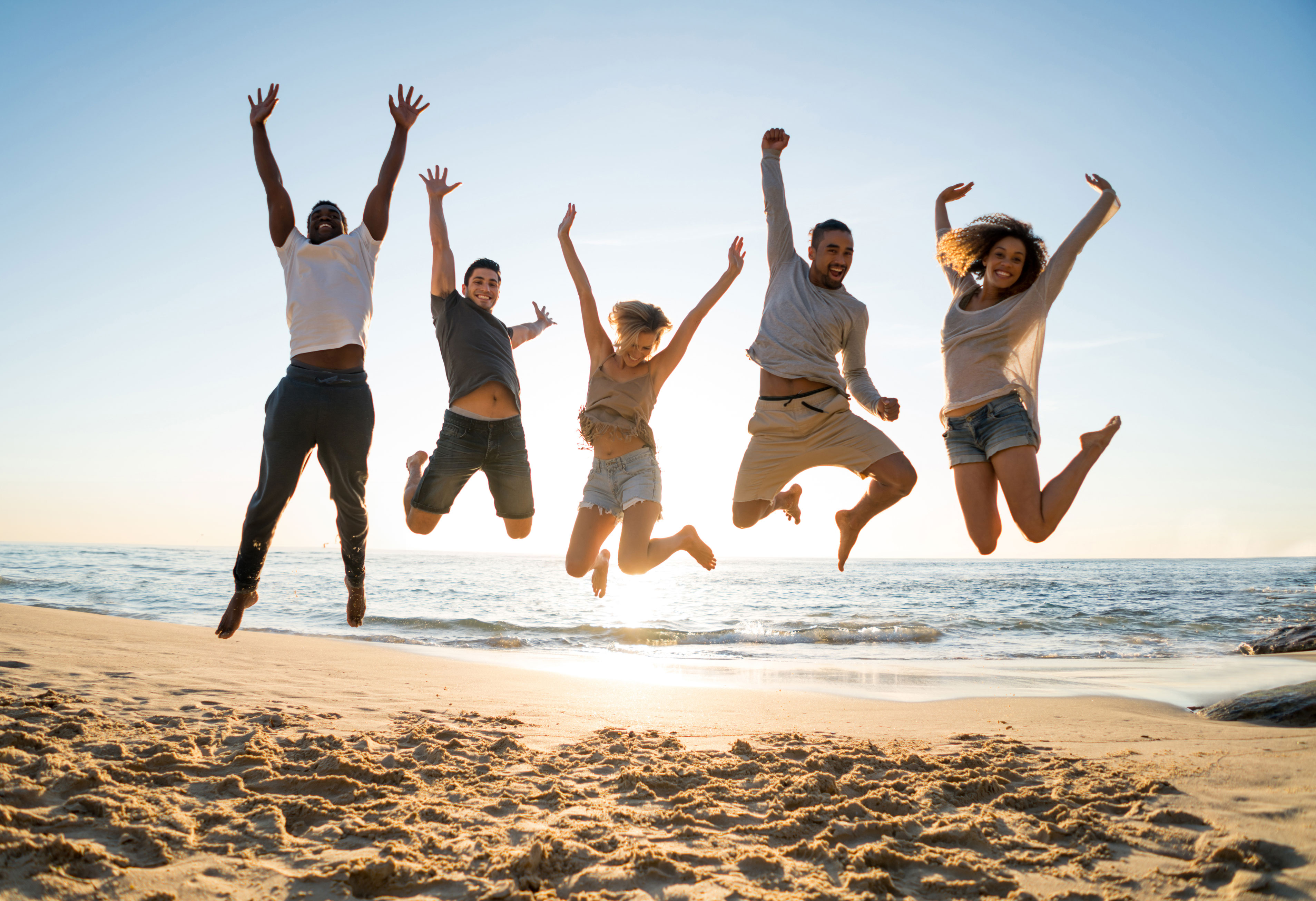 Group of friends jumping at the beach