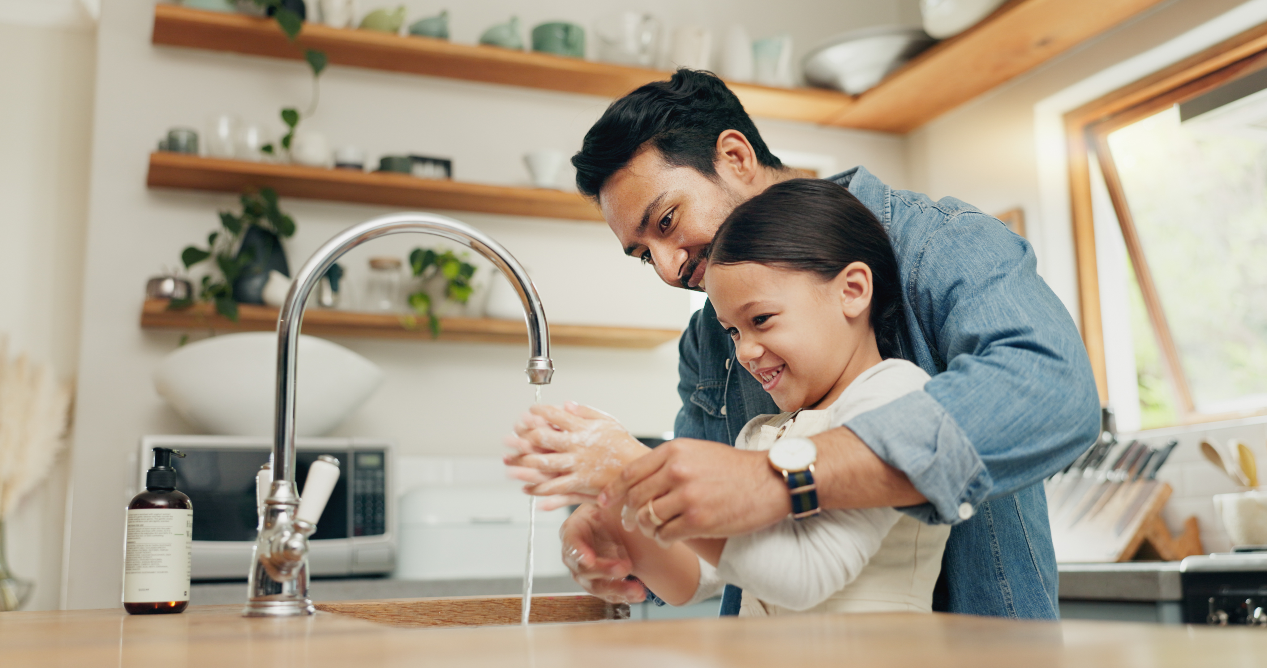 father and daughter washing hands