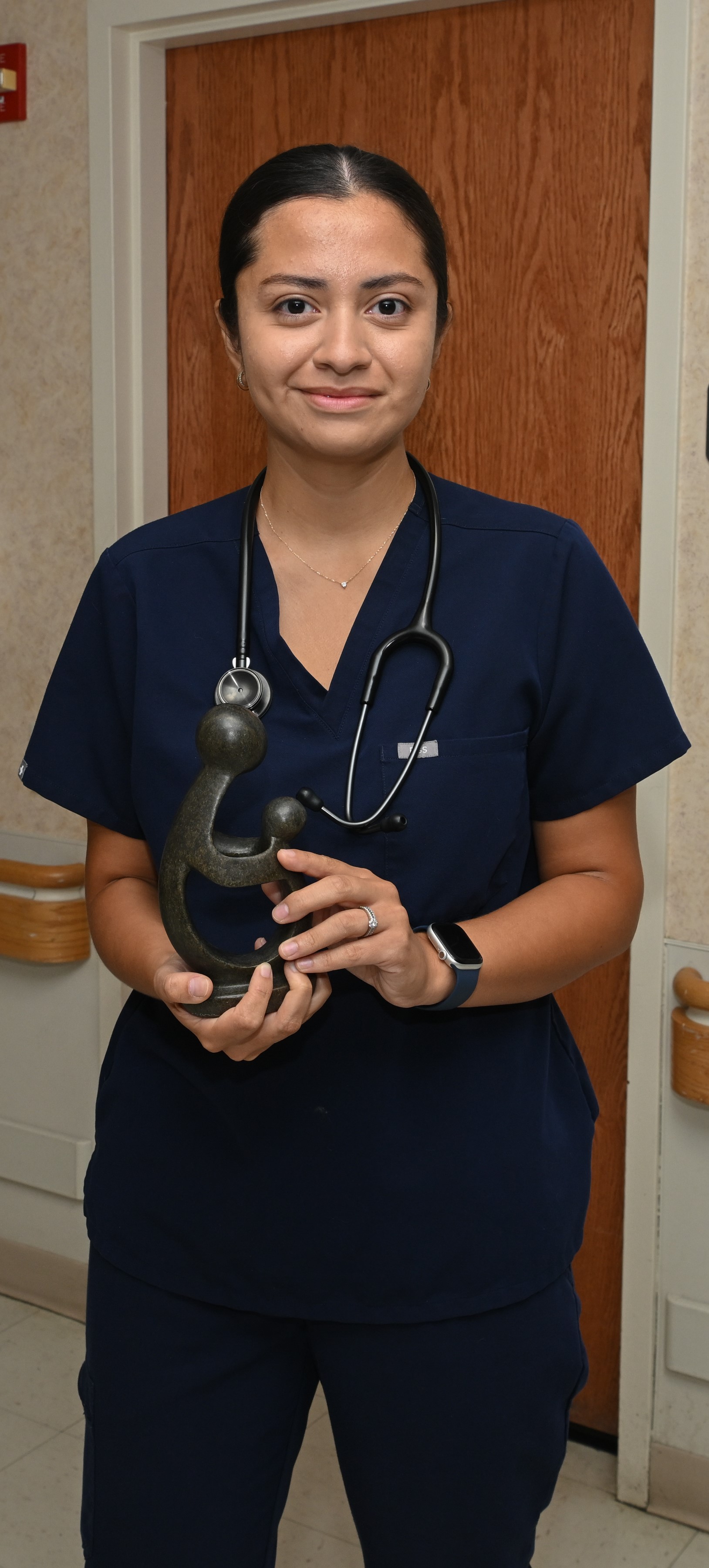 A woman holding her daisy award statue