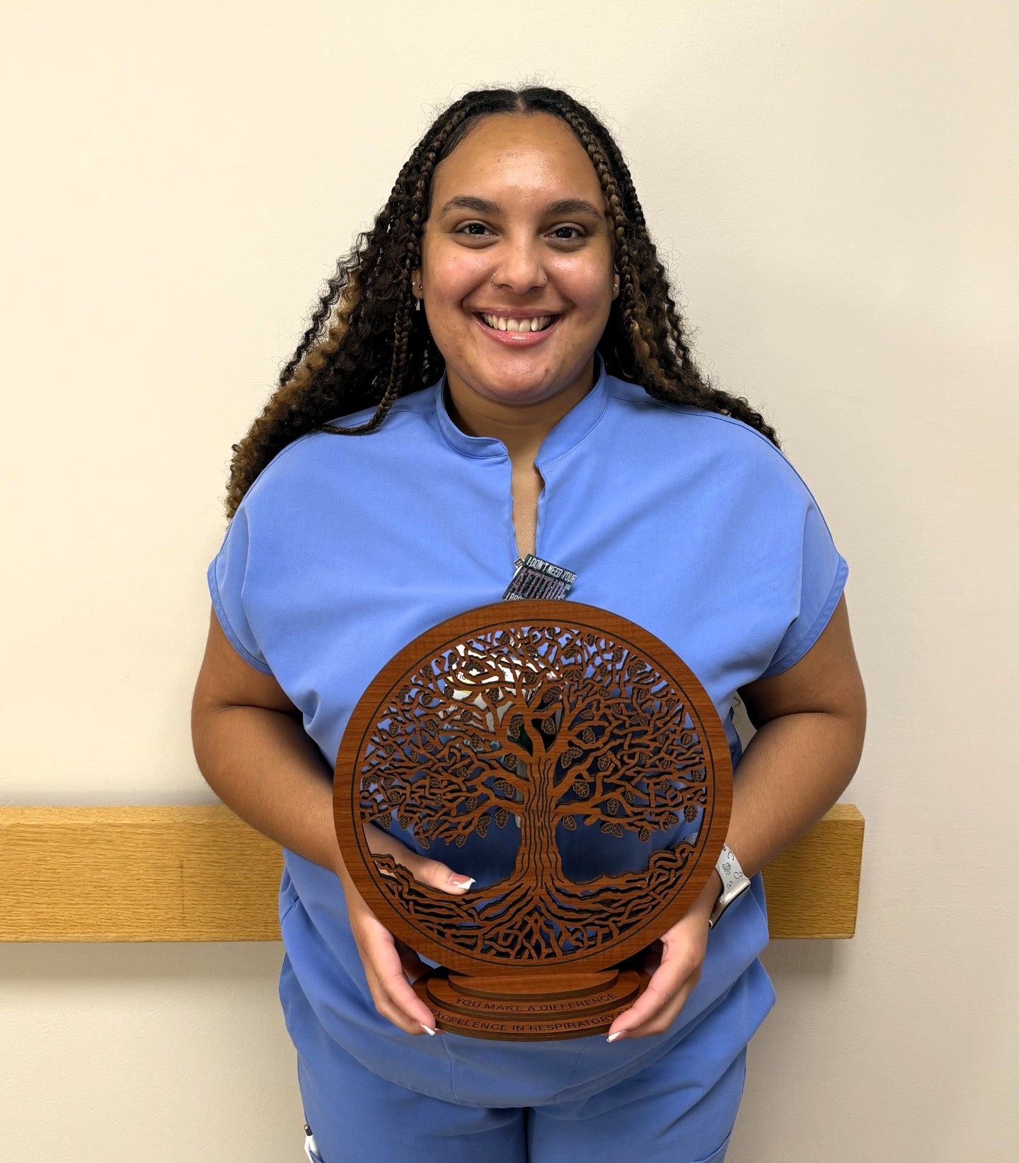 a woman holding a tree of life award in front of her