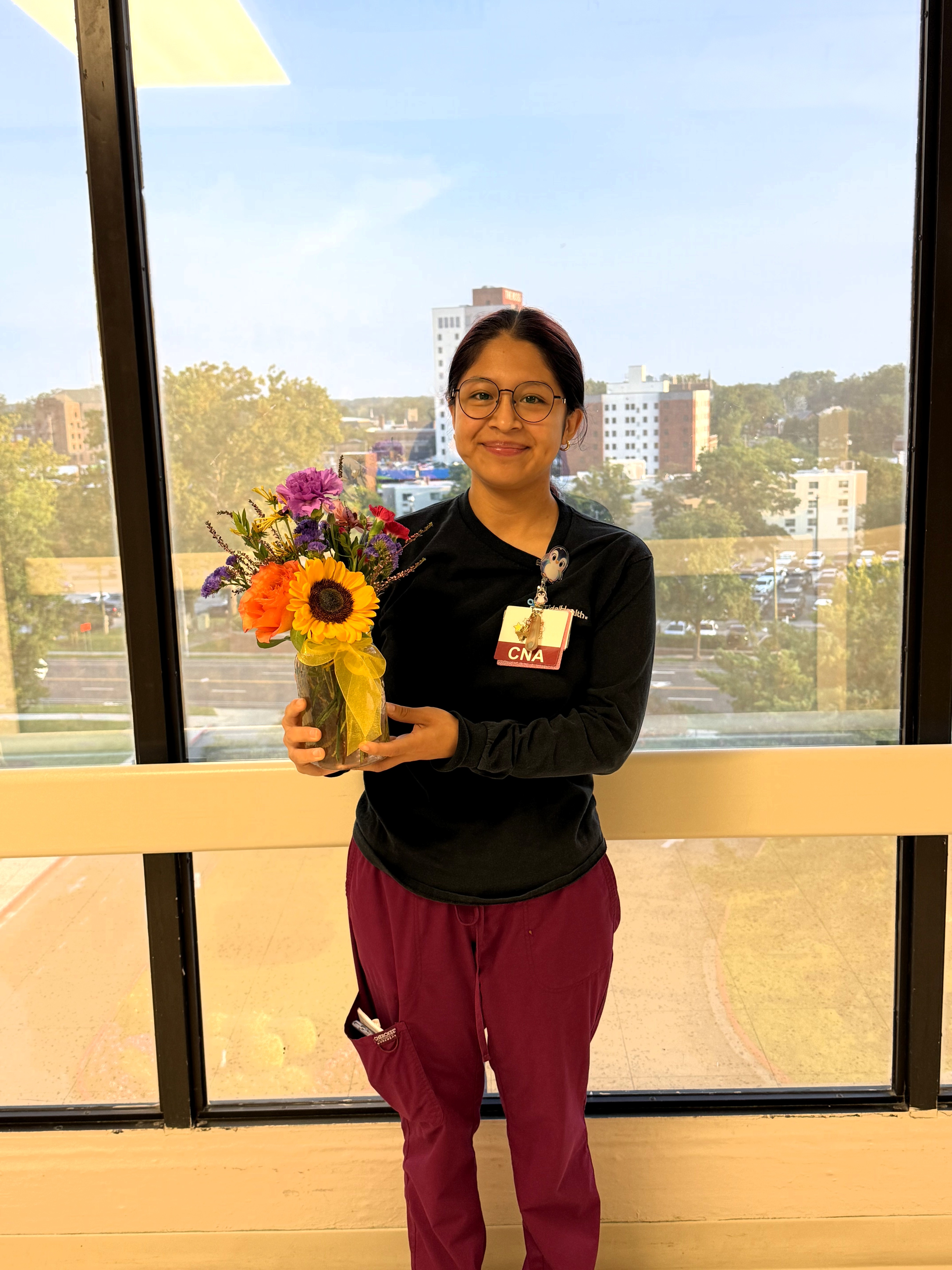 a woman in front of glass windows with flowers