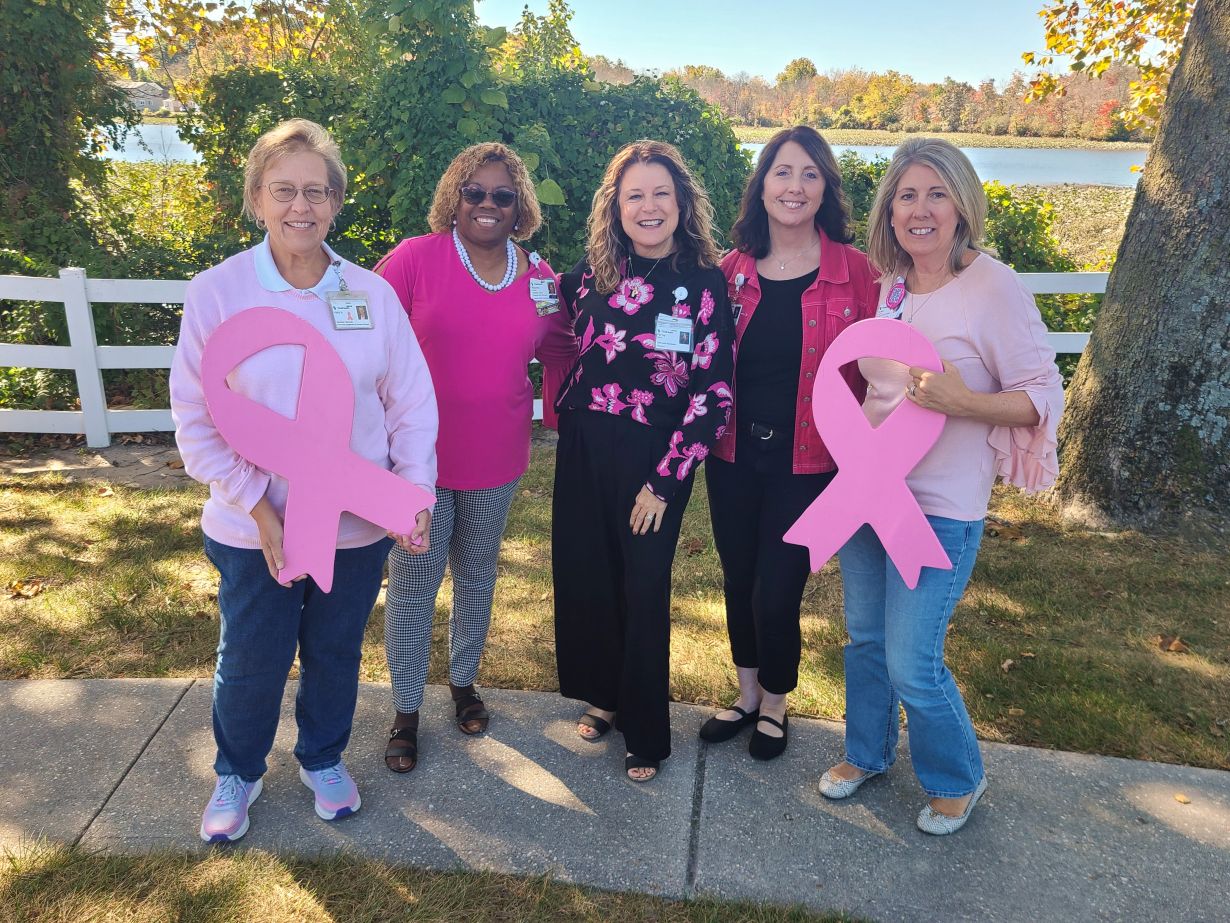 a group of women in pink holding up breast cancer ribbons