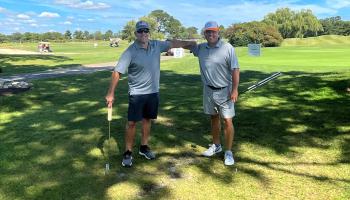 Warfield Memorial Golf classic, two men with golf clubs on a beautiful day