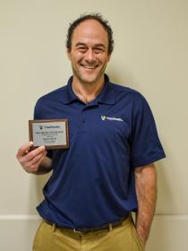 A man holding his award to his side