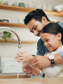father and daughter washing hands
