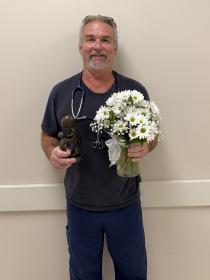 a man with a stethoscope holding daisies
