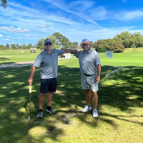Warfield Memorial Golf classic, two men with golf clubs on a beautiful day