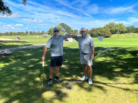 Warfield Memorial Golf classic, two men with golf clubs on a beautiful day