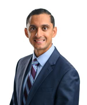 a doctor in a blue suit posing for his portrait