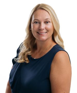a blonde haired woman in a navy shirt posing for a portrait