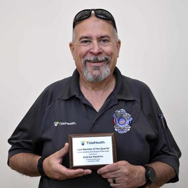 a man holding his award in front of him with sunglasses on his head