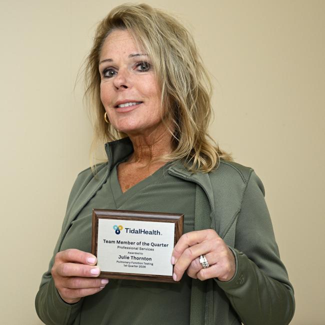 a woman holding her award in front of her