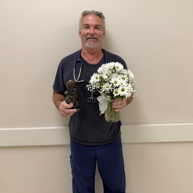 a man with a stethoscope holding daisies