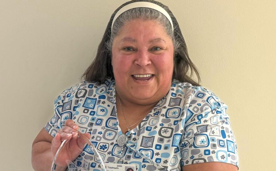 A woman smiling holding an award
