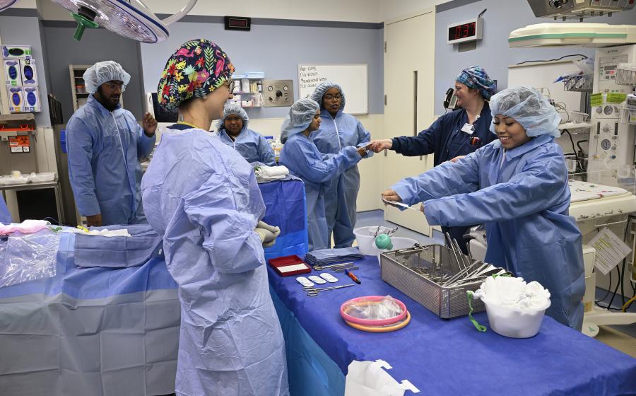 Students in operating room wearing surgical attire