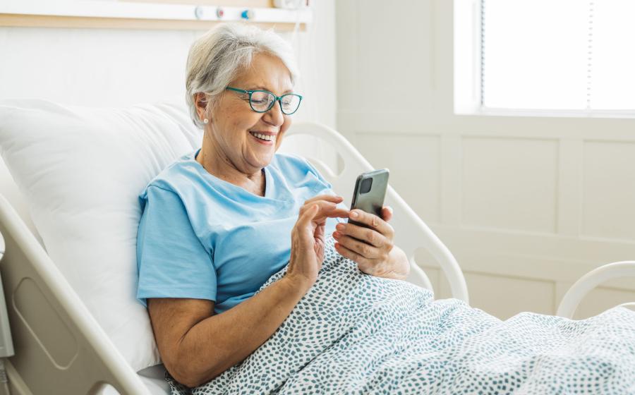 Elderly woman on phone in hospital bed
