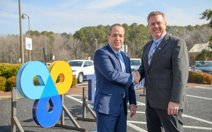 Don Owrey and Steve Leonard shake hands in front of the new TidalHealth sign that will go on the TidalHealth Atlantic building. 