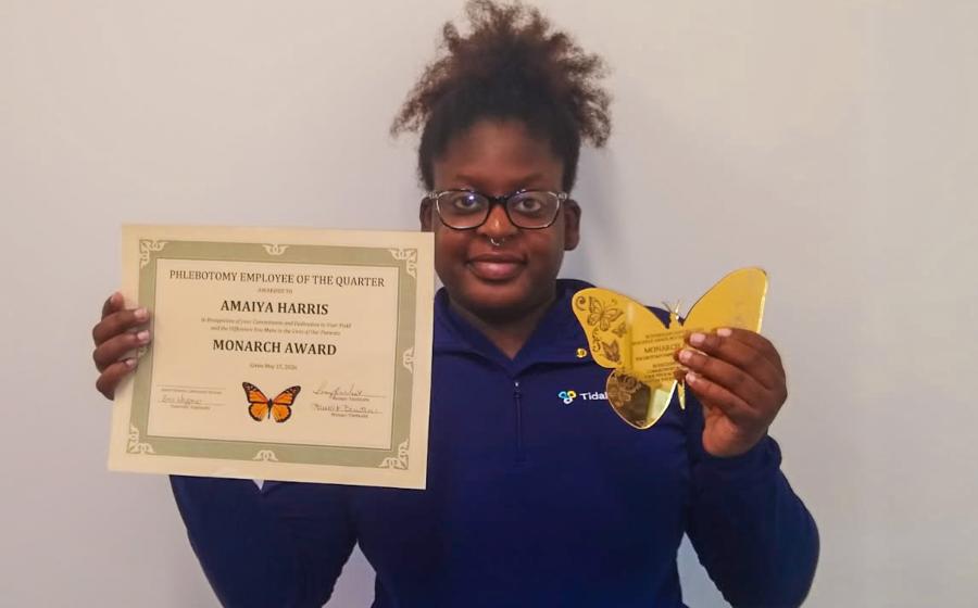 a woman with her hair up holding up awards