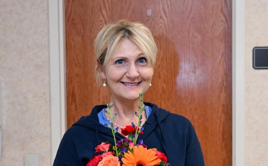woman with blonde hair holding flowers