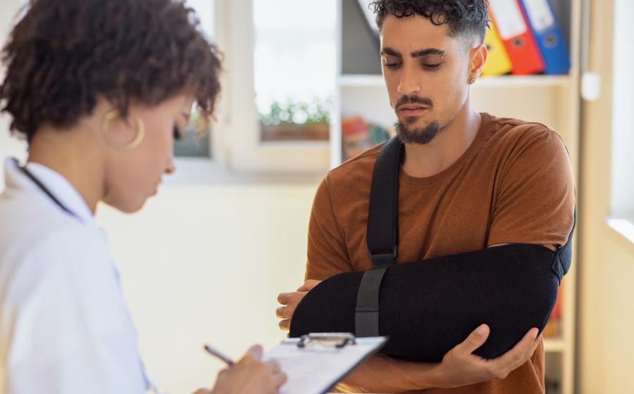 man in sling with dr taking notes