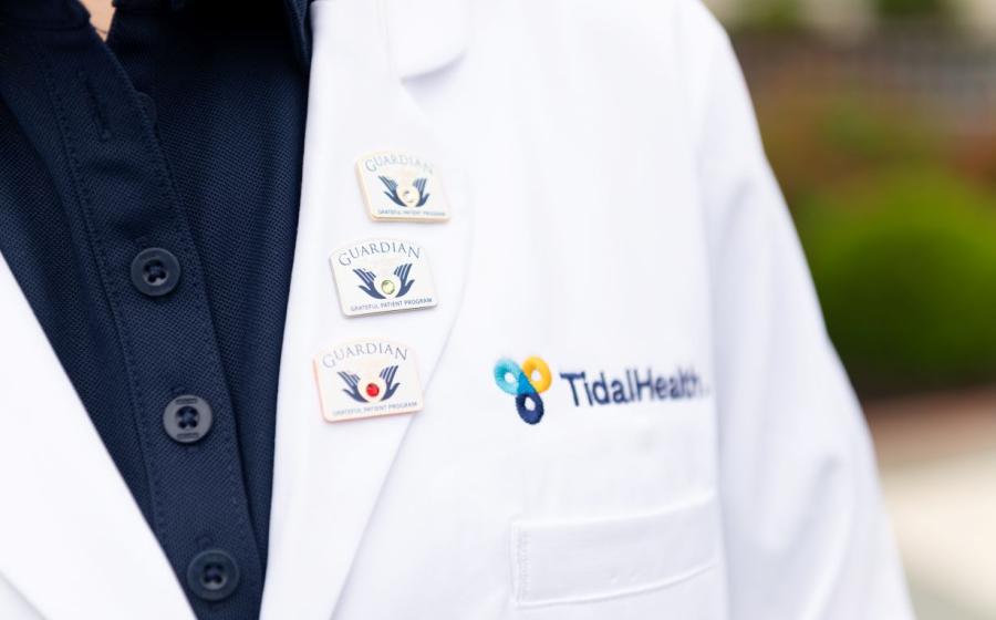 3 pins on the lapel of a white coat